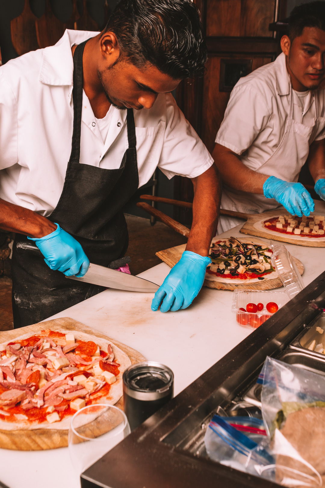 Cherry tomatoes being sliced in the kitchen at Don Tonito's Pizzeria