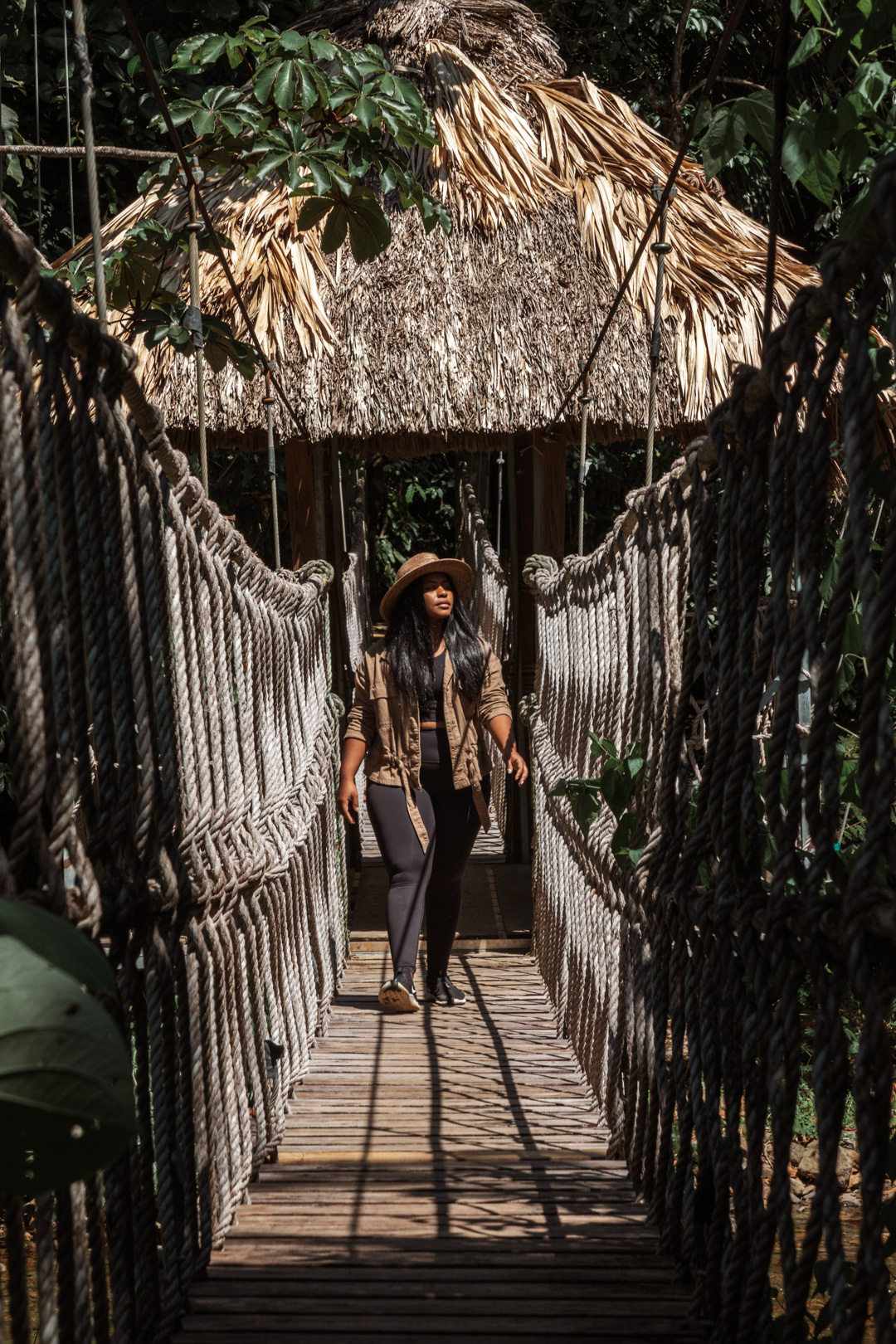 A guest standing on one of the rope bridges at The Rainforest Lodge at Sleeping Giant Resort