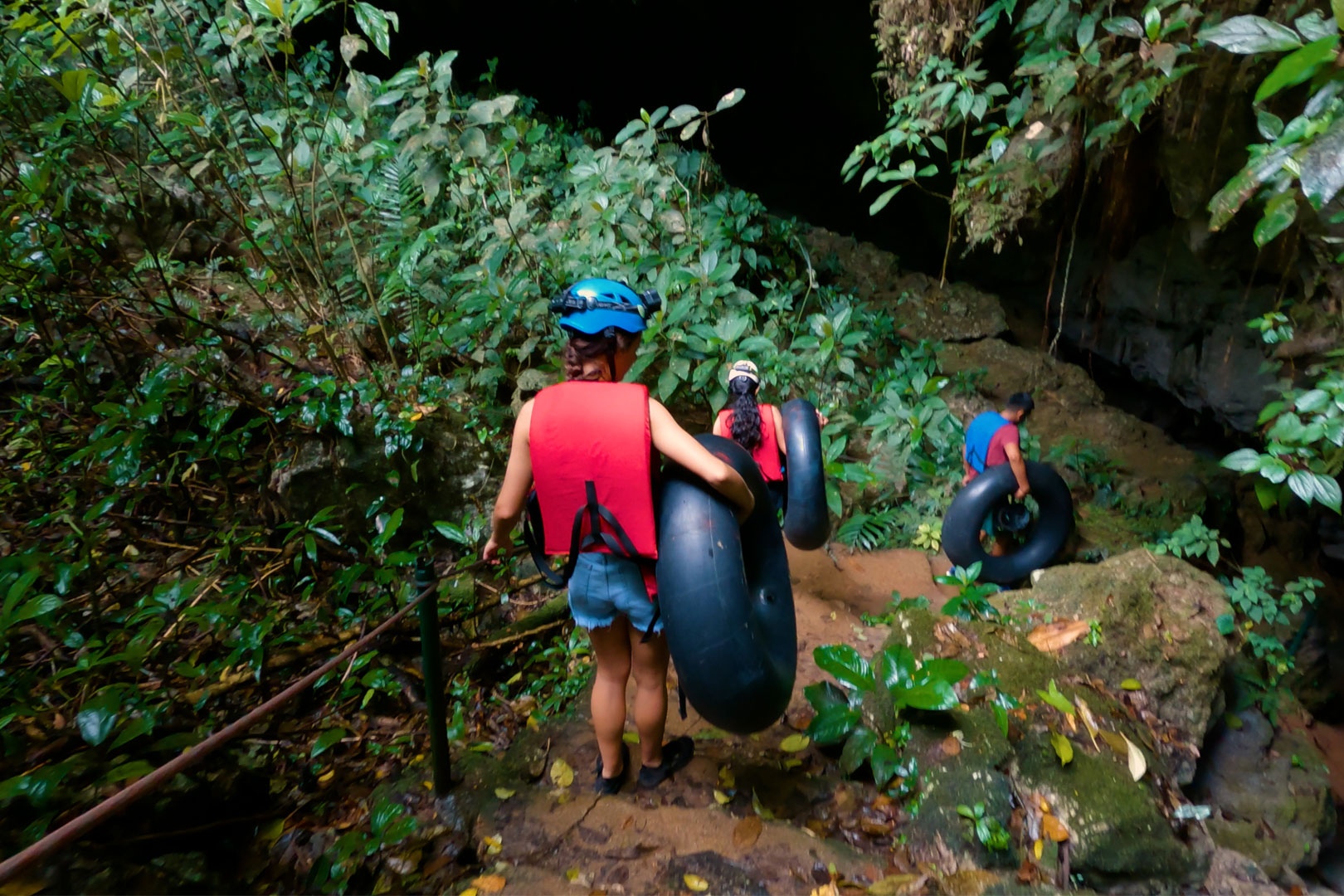 A group of guests entering St. Herman's Cave for the beginning of their Cave Tubing Adventure at The Rainforest Lodge at Seeping Giant Resort