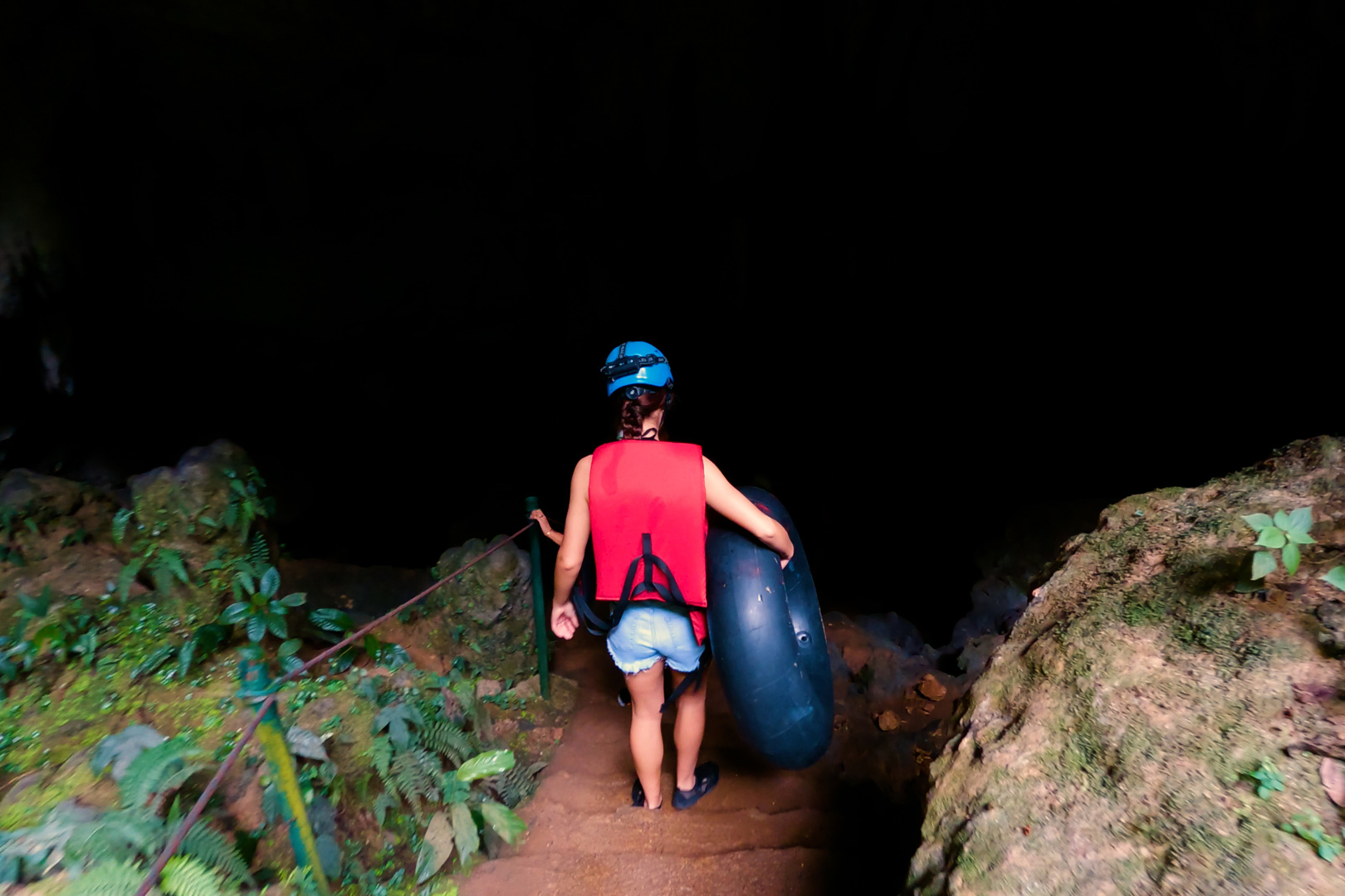 A group of guests entering St. Herman's Cave for the beginning of their Cave Tubing Adventure at The Rainforest Lodge at Seeping Giant Resort