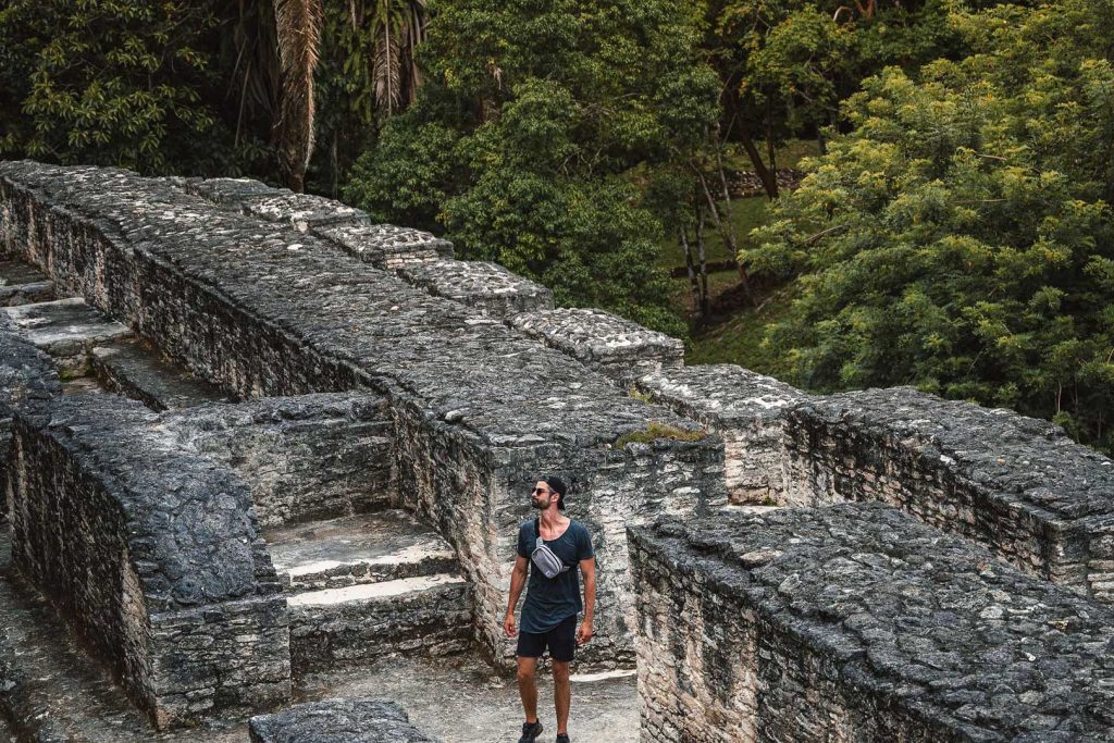 A guest standing on top of "El Pillar" at the Xunantunich Maya Site