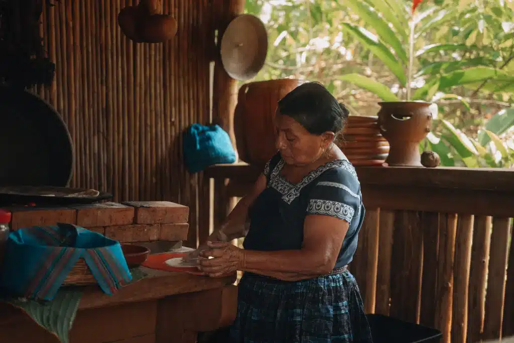 A Maya woman hand pressing tortillas during the Maya cooking class the Rainforest Lodge at Sleeping Giant Resort