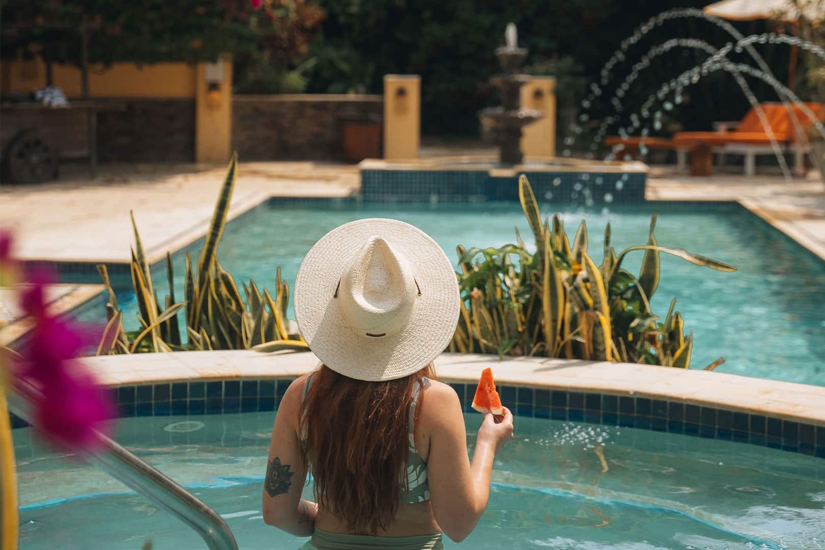 A guest eating a watermelon in the hot tub at The Rainforest Lodge at Sleeping Giant