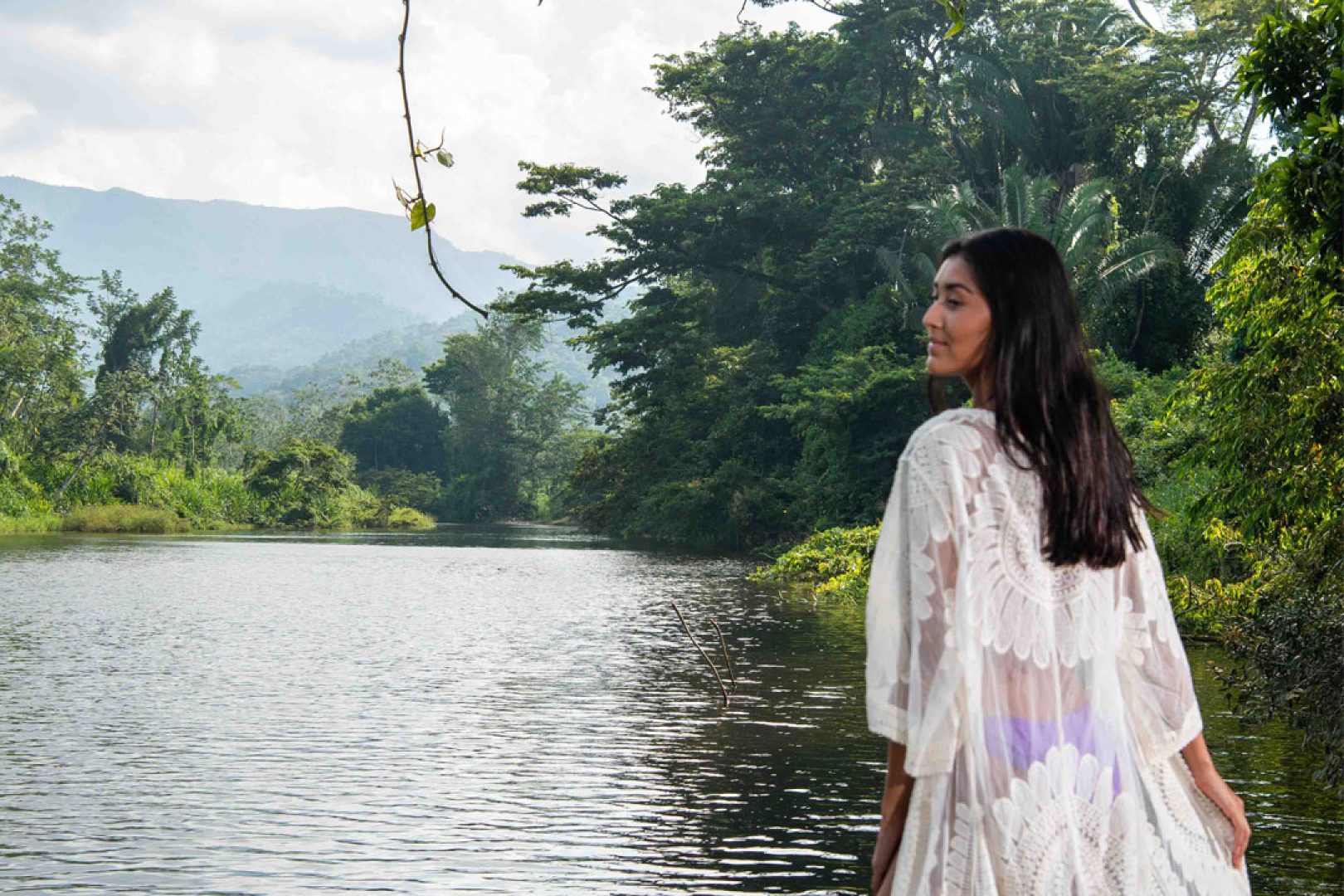 A guest in a bathrobe standing by the riverbank at The Rainforest Lodge at Sleeping Giant Resort